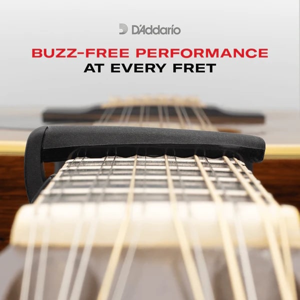 Close-up of a guitar neck and strings with a black fret nut; advert for D'Addario buzz-free performance at every fret.